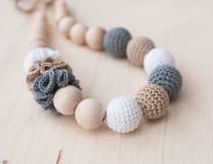 a crocheted necklace with wooden beads on a table