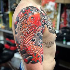 a man with a tattoo on his arm has a koi fish and flowers on it