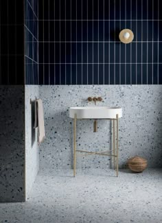 a white sink sitting under a bathroom mirror next to a blue tiled wall and floor