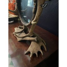 a wooden table topped with a mirror and antler horns on top of it's sides