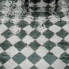 a black and white checkered tile floor with water droplets