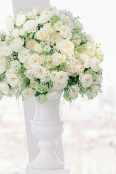 a white vase filled with lots of white flowers