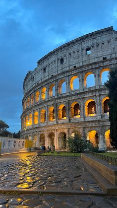 the roman colossion at night with its lights on and steps leading up to it