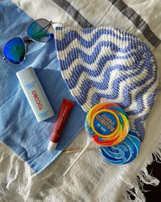 an assortment of personal care items laid out on top of a towel and beach towel