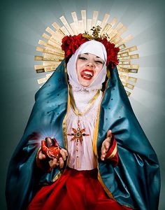 an image of a woman dressed as the virgin mary holding a red object in her hand