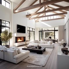 a large living room with white furniture and wood beams