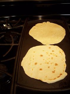 two tortillas sitting on top of an oven