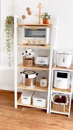 a kitchen shelf with pots, pans and other items on it in front of a white wall