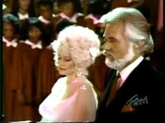 an old man and woman standing next to each other in front of choirs at a church