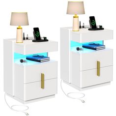 two white nightstands with electronic devices on them