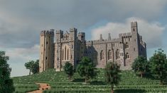 a large castle sitting on top of a lush green hillside next to trees and bushes