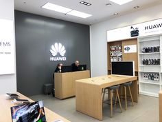 a man sitting at a desk in front of a phone store