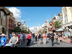 many people are walking down the street in front of buildings