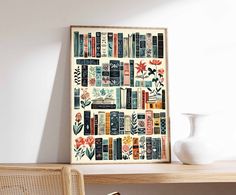 a wooden table topped with a white vase next to a framed book shelf filled with books