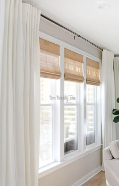 a living room filled with furniture and white curtains