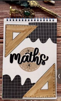 a notebook with the words maths written on it next to some scissors and pens