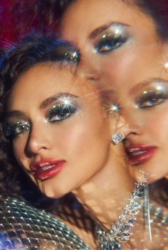 two beautiful women with makeup on their faces and one has her eyes covered in glitter