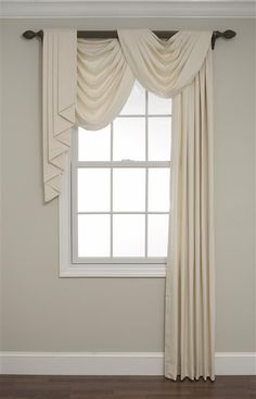 an empty room with a window and white curtains