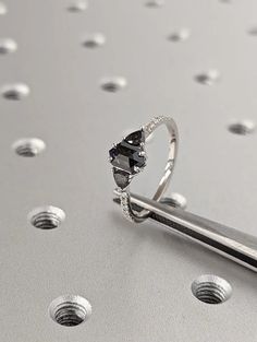 a diamond ring sitting on top of a piece of metal