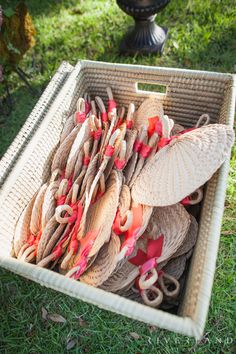 a basket filled with lots of different types of umbrellas on top of green grass