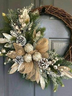 a wreath is hanging on the front door with pine cones and other holiday decorations around it