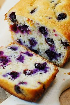 a loaf of blueberry bread sitting on top of a cutting board