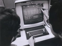 two people are using an old computer to learn how to use the keyboard and mouse