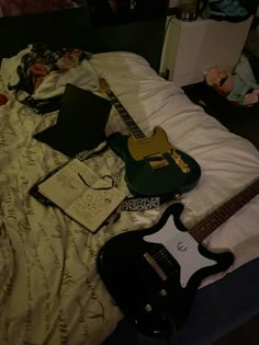 a bed with an electric guitar and other items on it