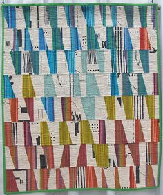 a multicolored quilt hanging on a wall