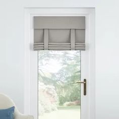 a white chair sitting in front of a window with blinds on it's side