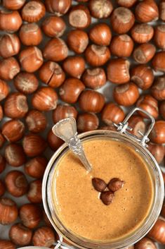 a jar filled with peanut butter surrounded by nuts