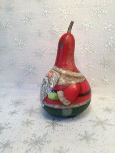 a red and green figurine sitting on top of a white table