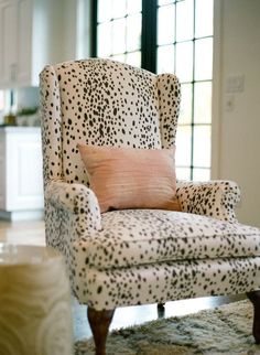 a leopard print chair in front of a window