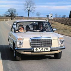 three people in a car driving down the road