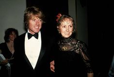 two people in tuxedos standing next to each other at a formal event together