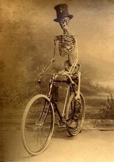 a skeleton riding a bike with a top hat on