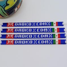 three lanyards with different colors and designs on them sitting next to a roll of tape