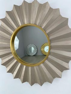 a round mirror sitting on top of a wooden table