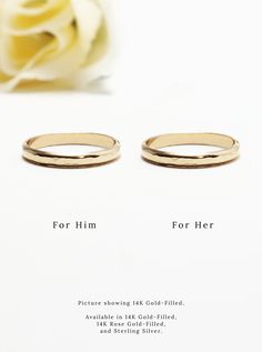 two gold wedding rings sitting next to a white rose with the words for him and her