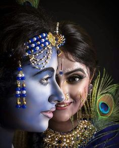 two women with painted faces and peacock feathers