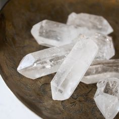 three ice crystals sitting on top of a wooden bowl