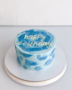 a blue and white birthday cake with the words happy birthday written on it