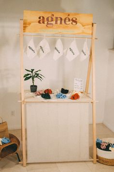 a wooden sign sitting on top of a white counter next to a potted plant