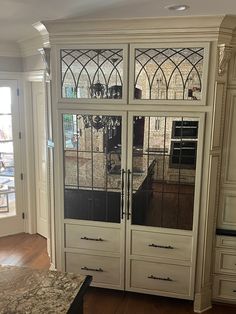 a cabinet with glass doors in a kitchen