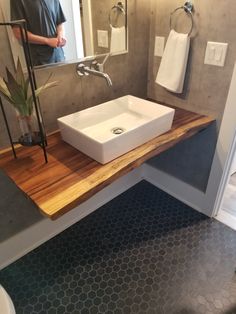 a bathroom with a sink, mirror and towel rack on the counter top in front of it