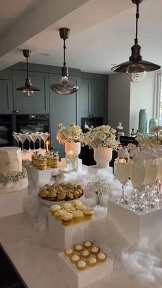 a table filled with lots of desserts and drinks on top of white counter tops