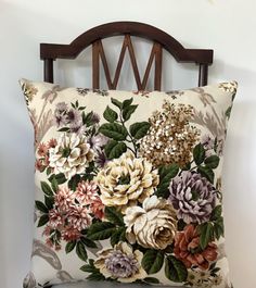 a pillow with flowers on it sitting on a chair