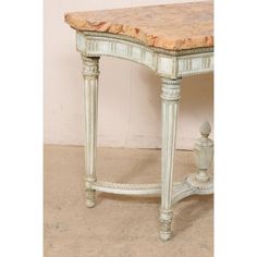 an antique white table with marble top