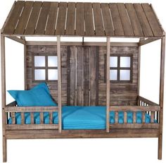 a wooden bed with blue pillows and a small house on it's roof top