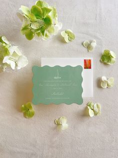 the wedding stationery is laid out on top of the table with flowers and petals